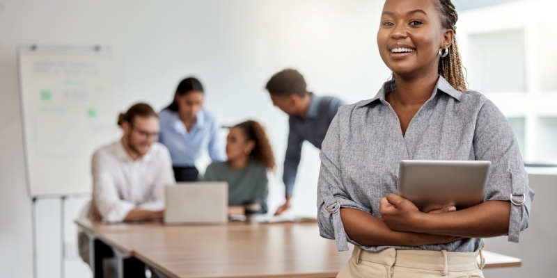 Women facing forward smiling as people in the background meet with each other